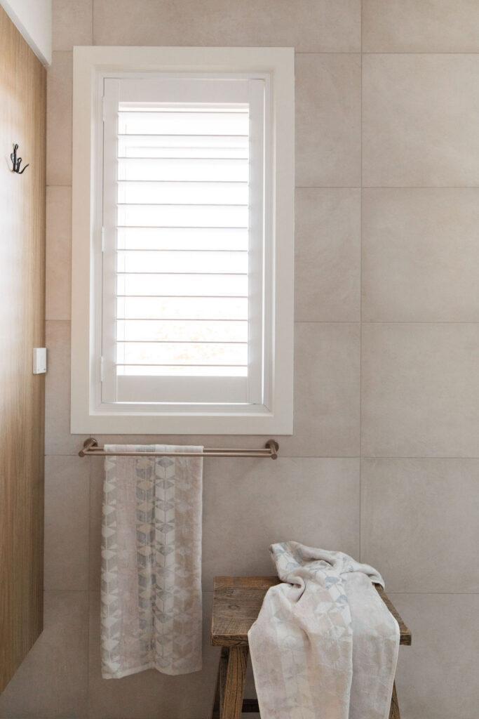 Meir champagne accessories against warm stone look tiles