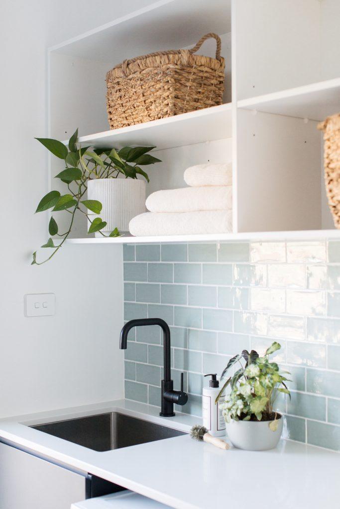 Black tap and stainless steel sink in laundry