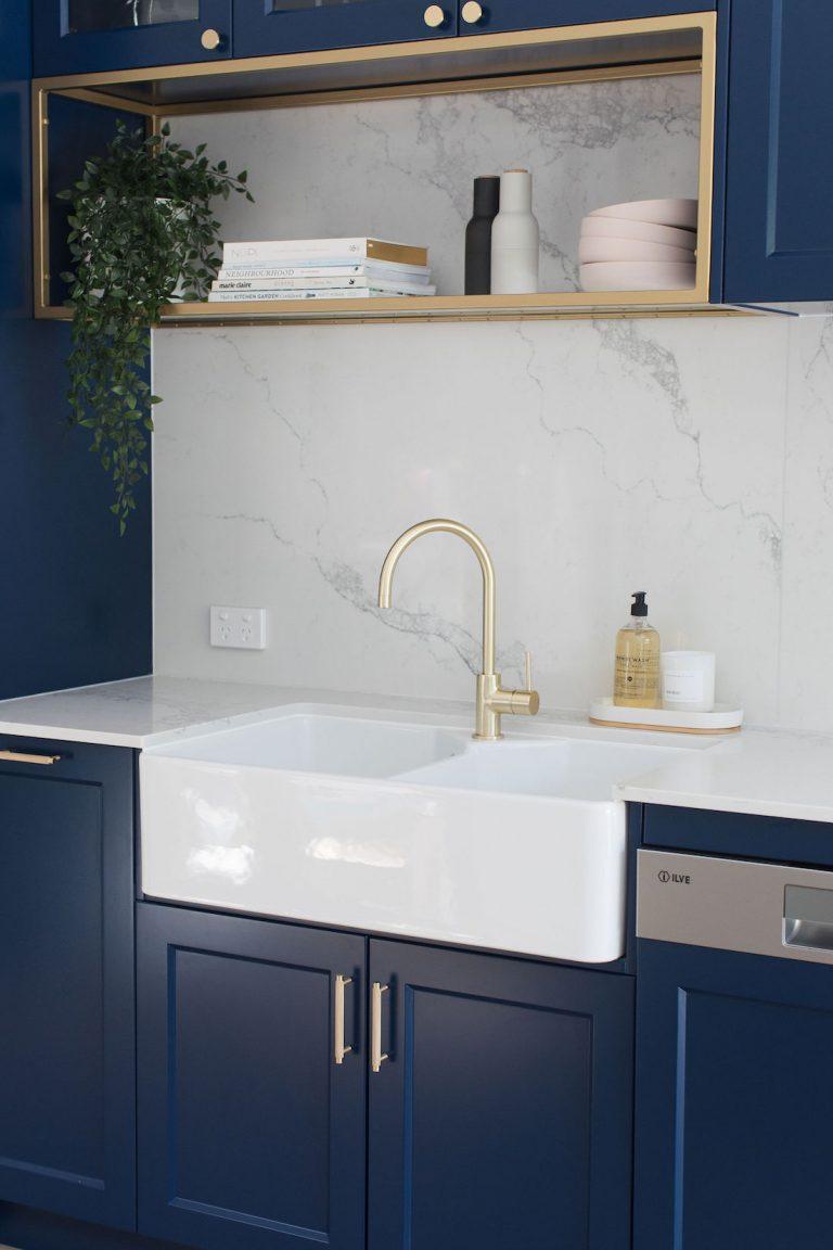 Luxe kitchen with navy cabinets: Deep blue kitchen with brass accents ...