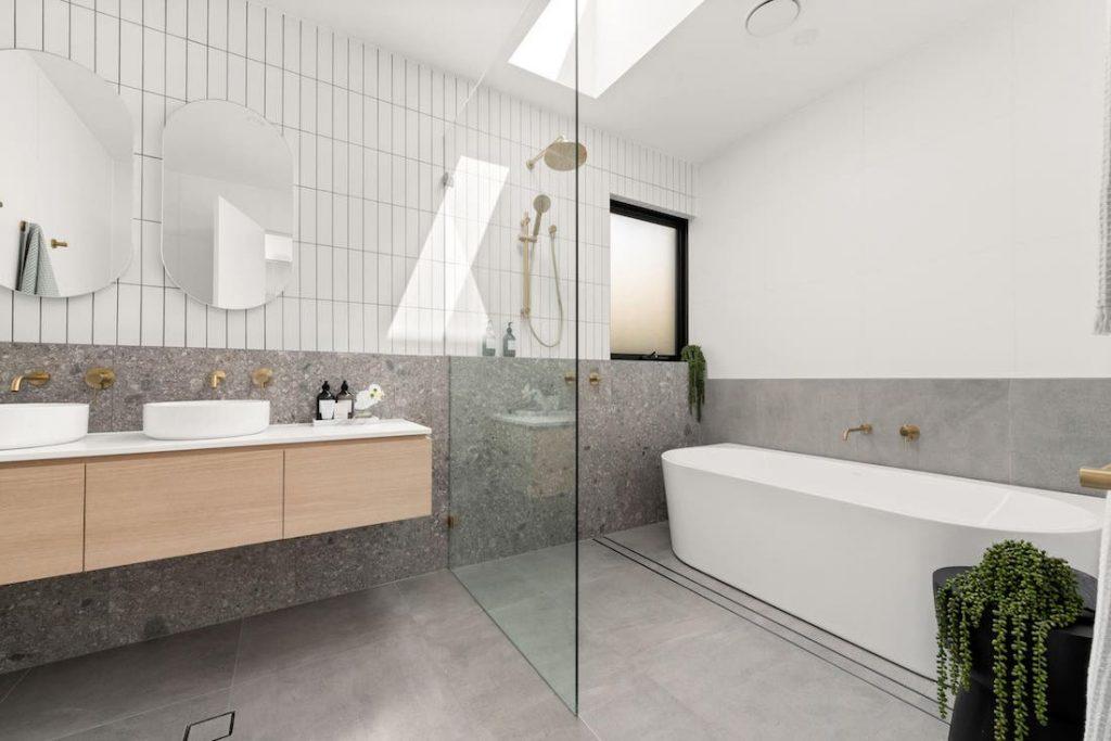 Boucaut Place by Status Living terrazzo look tile in bathroom, half height terrazzo tile around bathroom with subway tile above,