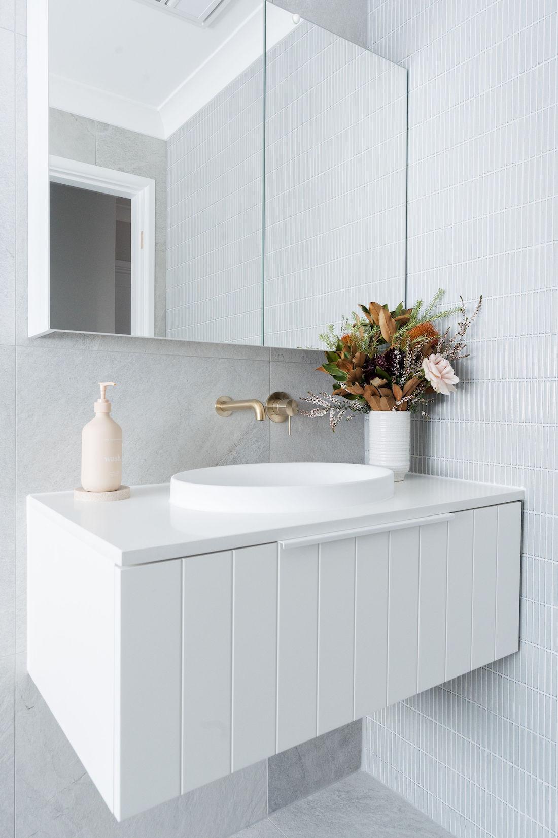 White vanity against grey stone-look tiles