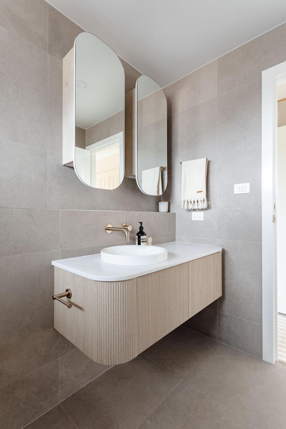 Curved vanity and mirrors in bathroom